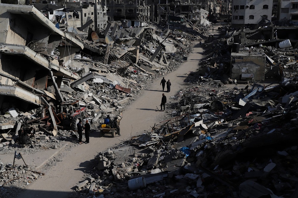 Palestinians walk through the destruction from the Israeli offensive in Jabaliya refugee camp in the Gaza Strip on Thursday, Feb. 29, 2024. (AP)