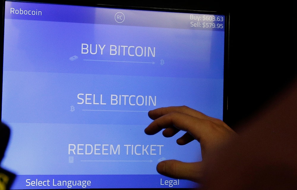 In this Thursday, March 20, 2014, file photo, Christopher David uses a Robocoin kiosk to sell bitcoins outside of the 500 Startups' Bitcoinference in Mountain View, Calif.(AP)