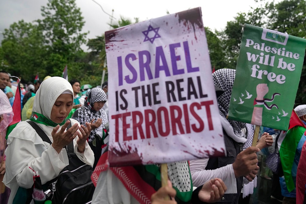 Protesters display posters as they pray during a rally in support of the Palestinians in Gaza, outside the US Embassy in Jakarta, Indonesia, Saturday, March 9, 2024.(AP)