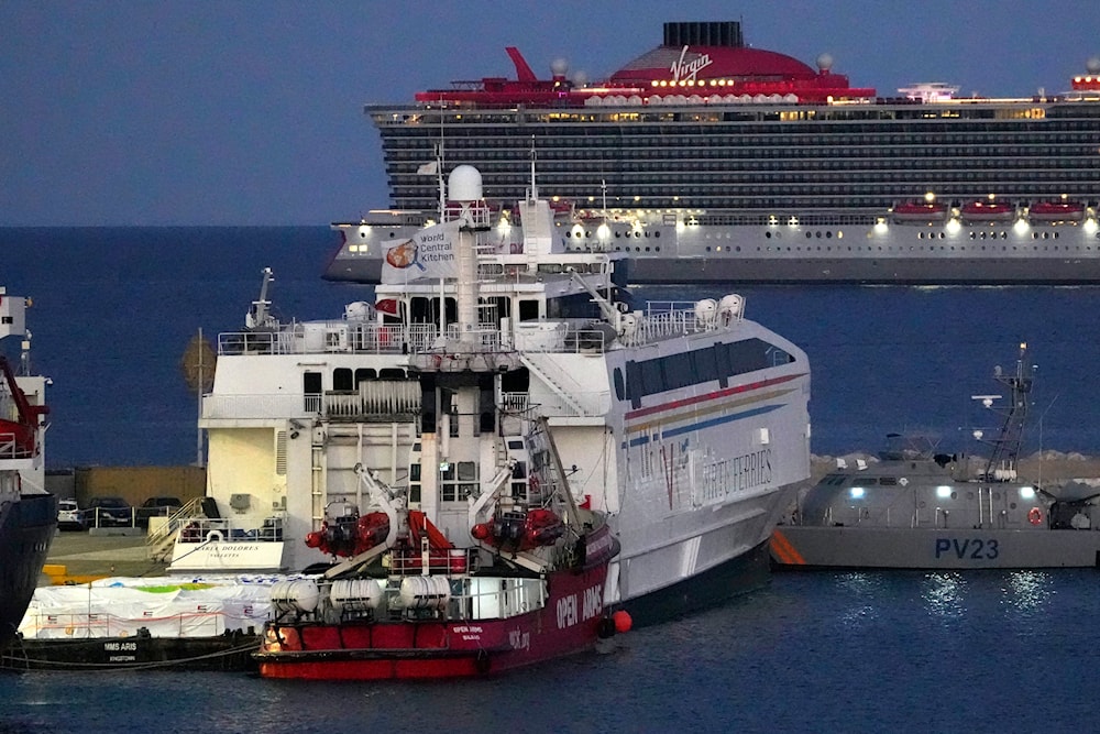 Aid packages, left, on a platform near the ship owned by Open Arms aid group, center front, as it prepares to ferry some 200 tonnes of rice and flour directly to Gaza, at the port in Larnaca, Cyprus, Monday, March 11, 2024. (AP)