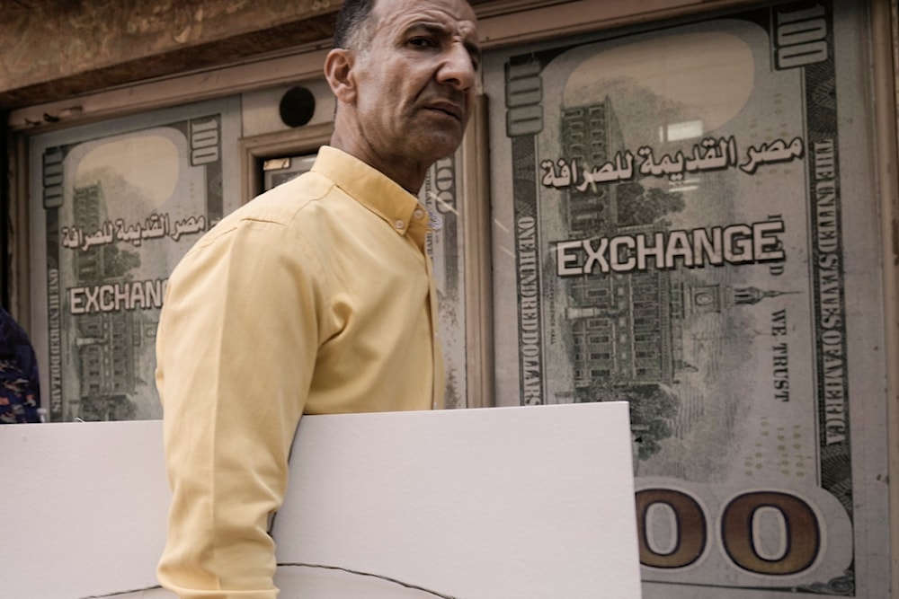 An Egyptian walks past an exchange office in Cairo, Egypt, Wednesday, March 6, 2024 (AP)