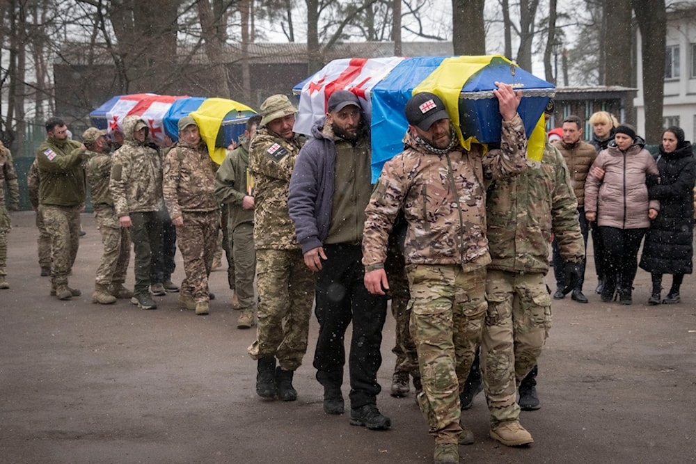 Volunteers of the Georgian legion carry coffins of soldiers who were killed in a battle against Russian troops, during a funeral ceremony in Kiev, Ukraine, Tuesday, March 12, 2024 (AP)