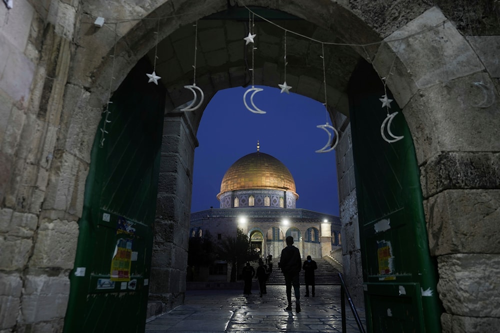Palestinians walk next to the Dome of Rock Mosque at the Al-Aqsa Mosque compound in al-Qus's Old City, on Sunday, March 10, 2024.(AP)