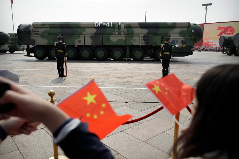 Spectators wave Chinese flags as military vehicles carrying DF-41 nuclear ballistic missiles roll during a parade to commemorate the 70th anniversary of the founding of Communist China in Beijing on Oct. 1, 2019.(AP)