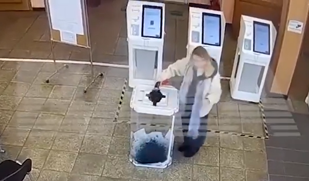 Surveillance footage shows a woman dumping dye into a ballot box at a Russian voting station (Screengrab)