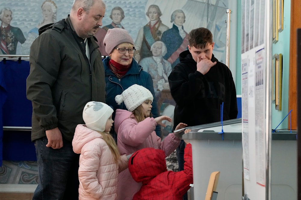 A family votes at a polling station located in a school during the presidential elections in St. Petersburg, Russia, Saturday, March 16, 2024. (AP)
