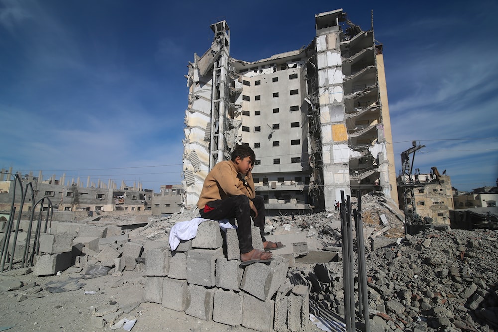 A Palestinian boy sits outside a residential building destroyed in an Israeli strike in Rafah on March 9, 2024. (AP)
