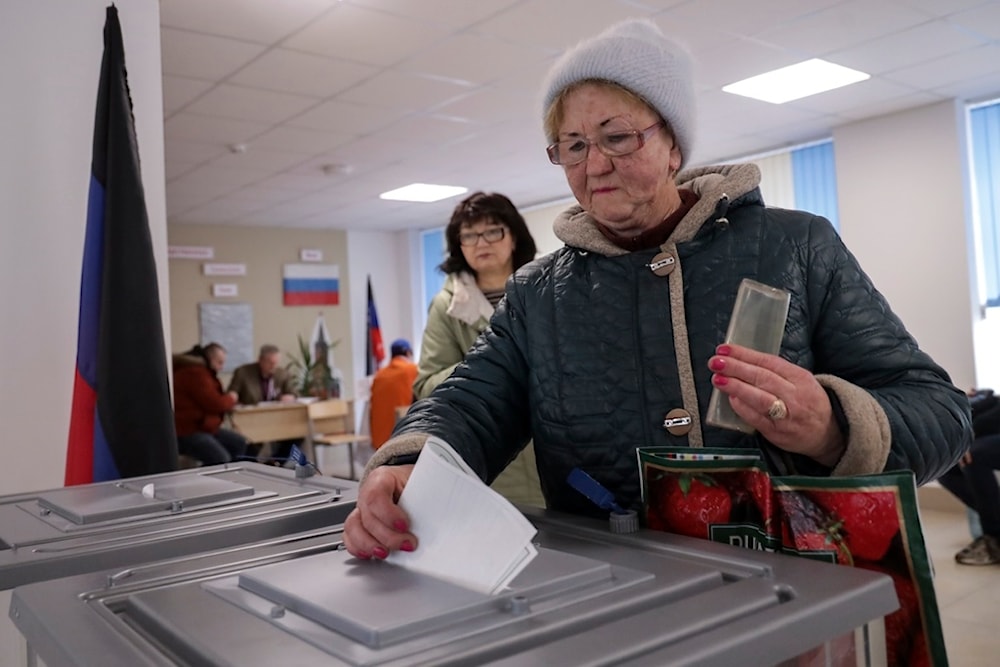 A woman casts her ballot at a polling station during a presidential election in Mariupol in Russian-controlled Donetsk region of eastern Ukraine, Sunday, March 17, 2024. (AP)