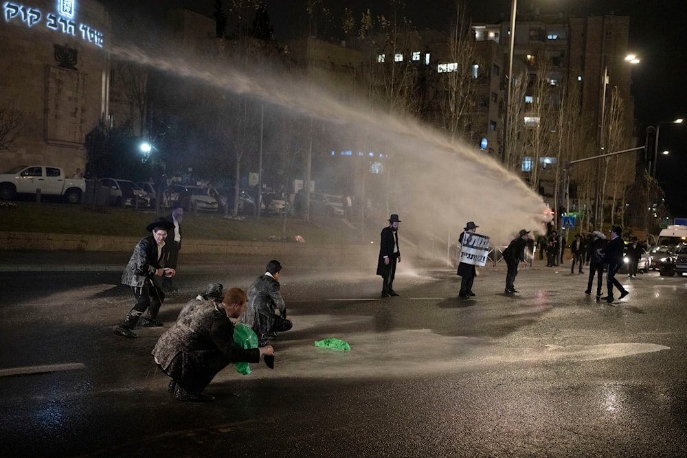 Israeli occupation police use skunk water cannon to disperse ultra-Orthodox Jewish men blocking a street during a protest in al-Quds, occupied Palestine, Monday, March 18, 2024.(AP)
