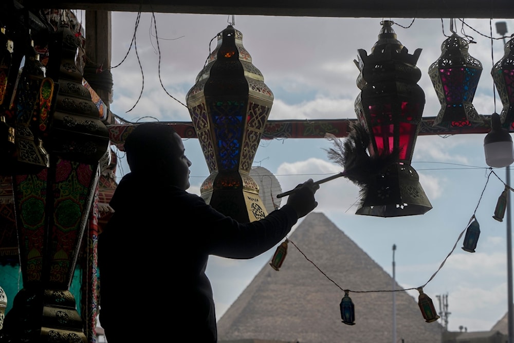 A worker prushes traditional lanterns at a shop in front of Giza Pyramids ahead of the upcoming Muslim fasting month of Ramadan, in Cairo, Egypt, Thursday, March 7, 2024. (AP)