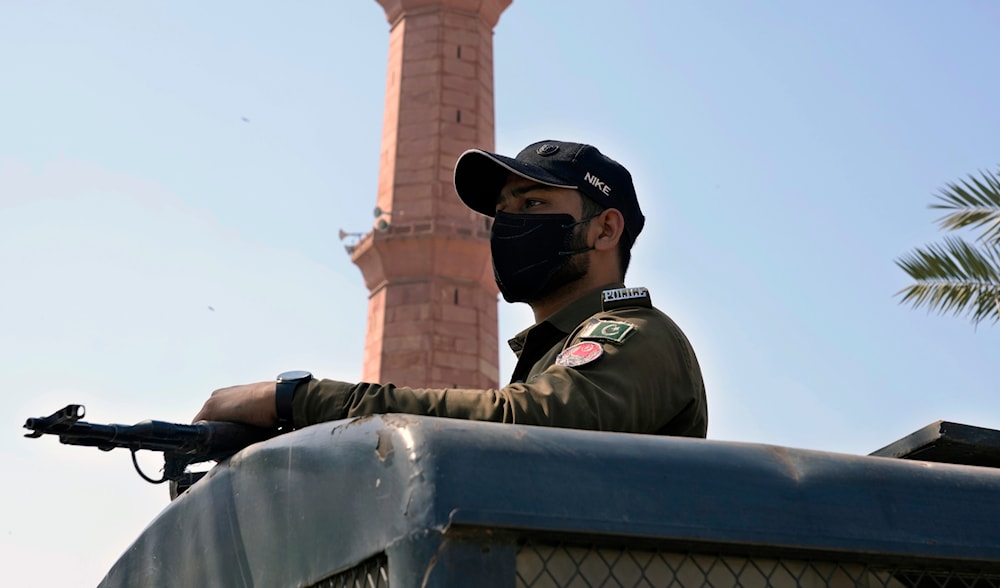 A police officer stands alert on the top of a vehicle outside the historical Badshahi mosque in Lahore, Pakistan, Friday, March 15, 2024. (AP)