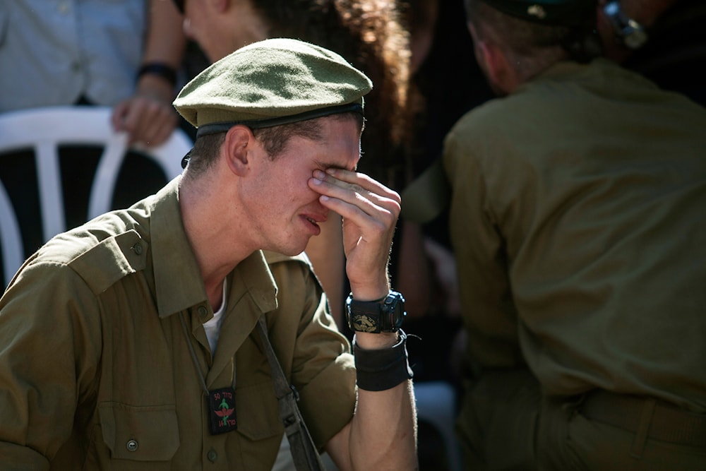 An Israeli soldier mourns over the grave of reserve Master Sgt. Yair Ashkenazy, 36, during his funeral at the military cemetery in Rehovot,' Israel', Friday, July 25, 2014. (AP)