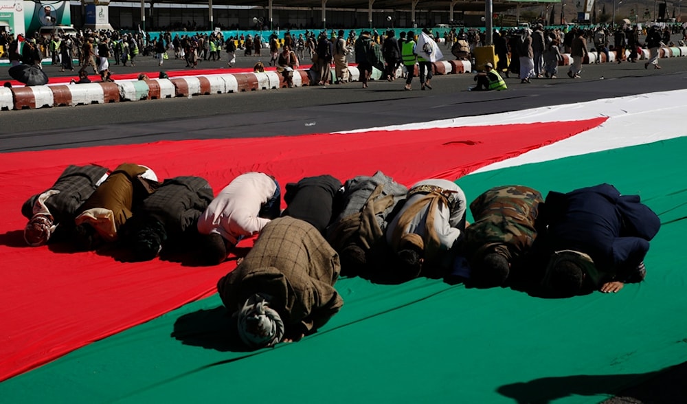 Houthi supportsers pray on a large Palestinian flag before a rally against the U.S.-led strikes on Yemen and Israel's war in Gaza Strip, in Sanaa, Yemen, Friday, Feb. 23, 2024. (AP)