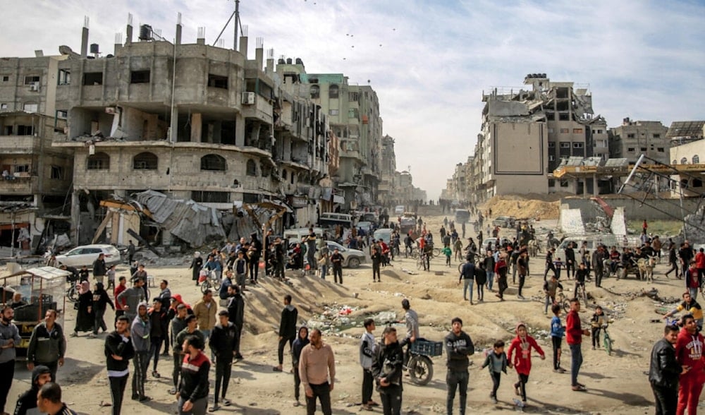 Palestinians gather in a street as humanitarian aid is airdropped in Gaza on March 1, 2024. (AFP)