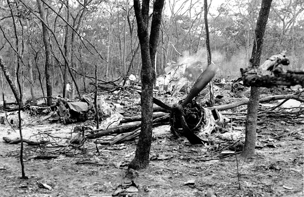 In this Sept. 19, 1961, file photo, searchers walk through the scattered wreckage of a DC6B plane in a forest near Ndola, Zambia (AP) 