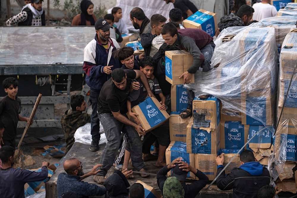 Palestinians obtain humanitarian aid in the Gaza Strip in Rafah, Sunday, Dec. 17, 2023 (AP)