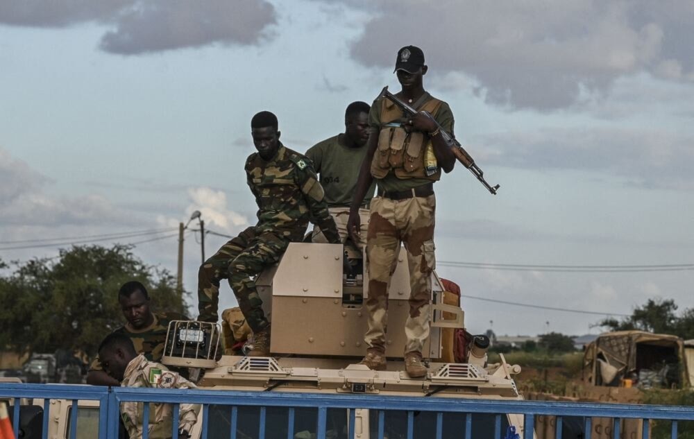 Nigerien servicemen stand guard in Niamey as protesters gather to demand the departure of the French military from Niger. (AFP)
