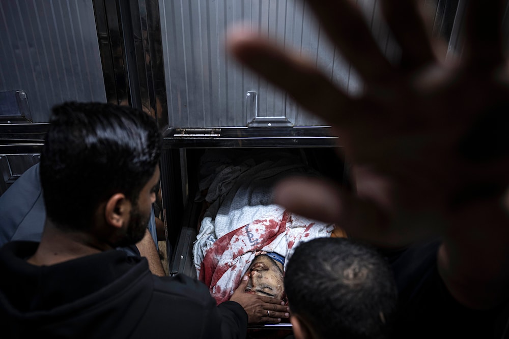 A Palestinian mourns another Palestinian man martyred by an Israeli airstrike, in the morgue of Al-Shifa Hospital in Gaza City on May 9, 2023. (AP)