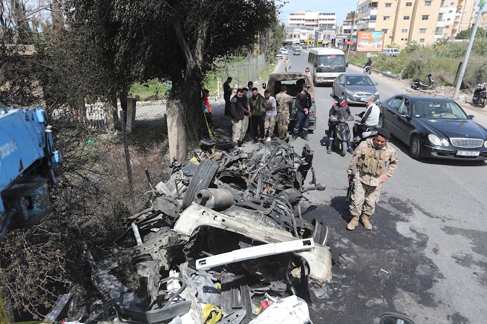 Lebanese army soldiers stand next to the car targeted by an Israeli drone on the southern outskirts of Tyre, Lebanon, Wednesday, March 13, 2024.(AP)