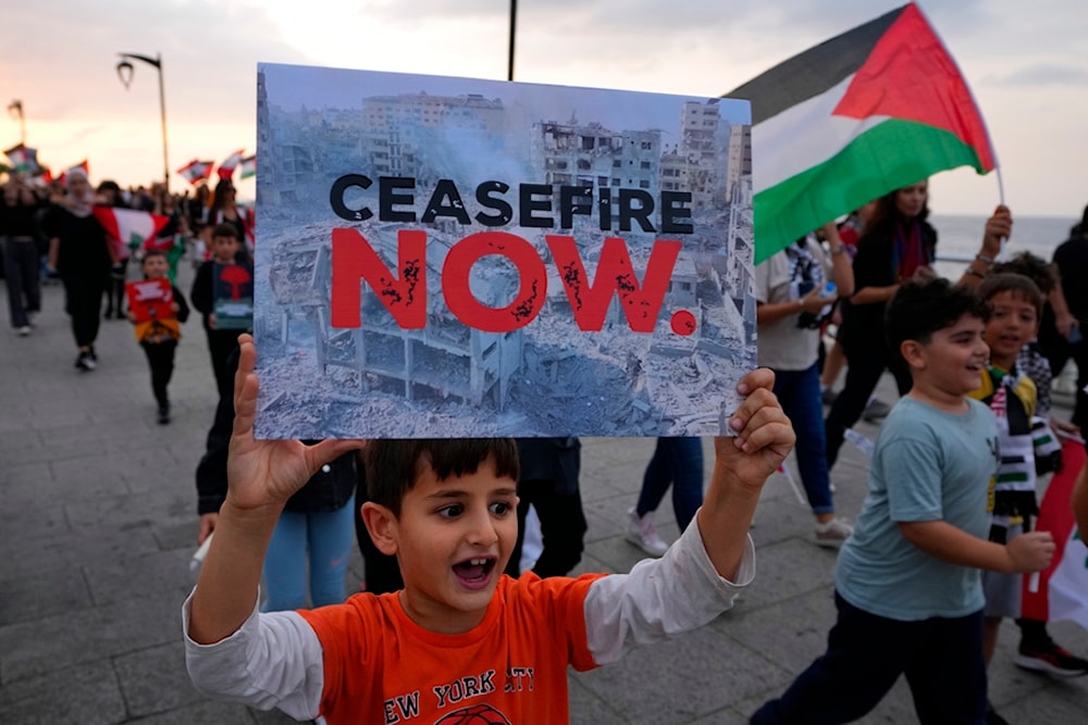 A child chants slogans as he holds a placard during a march against Israel's attack on the Gaza Strip, on the Mediterranean Sea corniche in Beirut, Lebanon, Friday, Nov. 10, 2023. (AP)