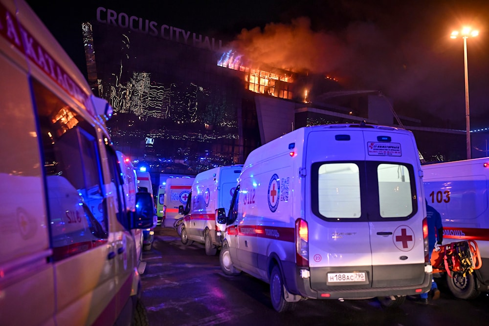 Ambulances park near a burning building of the Crocus City Hall on the western edge of Moscow, Russia, Friday, March 22, 2024. (AP)