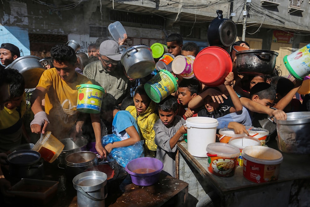 Palestinians crowd together as they wait for food distribution in Rafah, southern Gaza Strip, November 8, 2023 (AP)