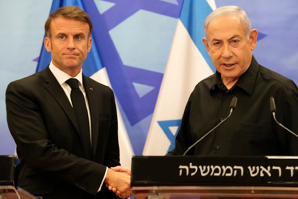 Israeli Prime Minister Benjamin Netanyahu, right, shakes hands with French President Emmanuel Macron after a joint press conference in occupied al-Quds, Tuesday, Oct. 24, 2023. (AP)