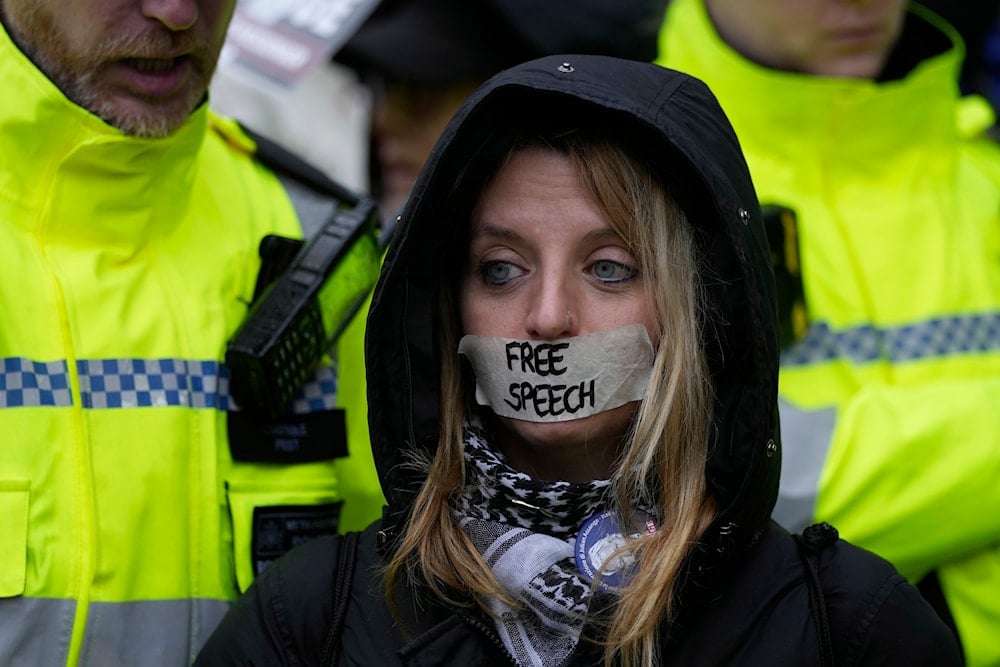 A protester stands outside the Royal Courts of Justice in London, Wednesday, Feb. 21, 2024. (AP)