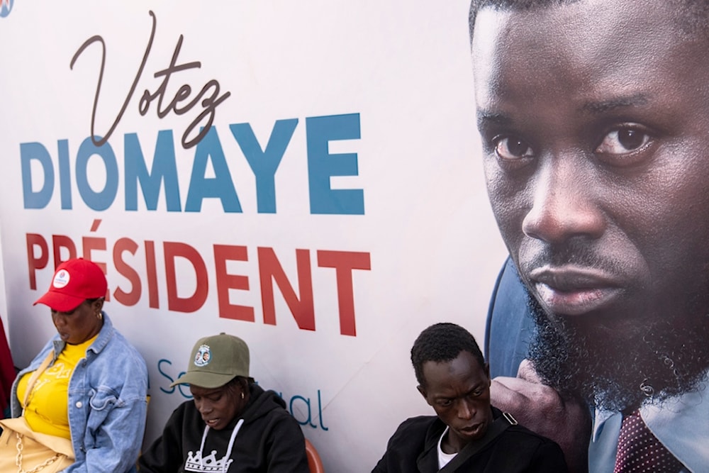 Supporters of presidential candidate Bassirou Diomaye Faye gather outside his campaign headquarters after preliminary results put him as the expected winner, in Dakar, Senegal, Monday, March 25, 2024. (AP)