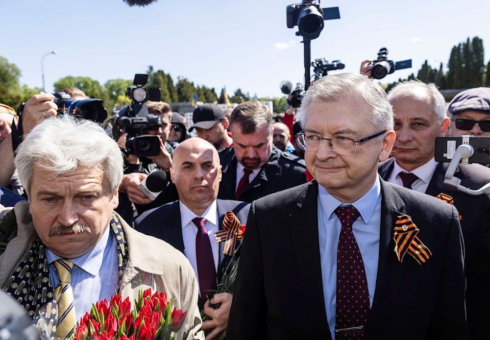 Russia's Ambassador to Poland Sergey Andreev, right, speaks to reporters in front of a memorial site to Red Army soldiers in Warsaw, Poland, Tuesday May 9, 2023. (AP)