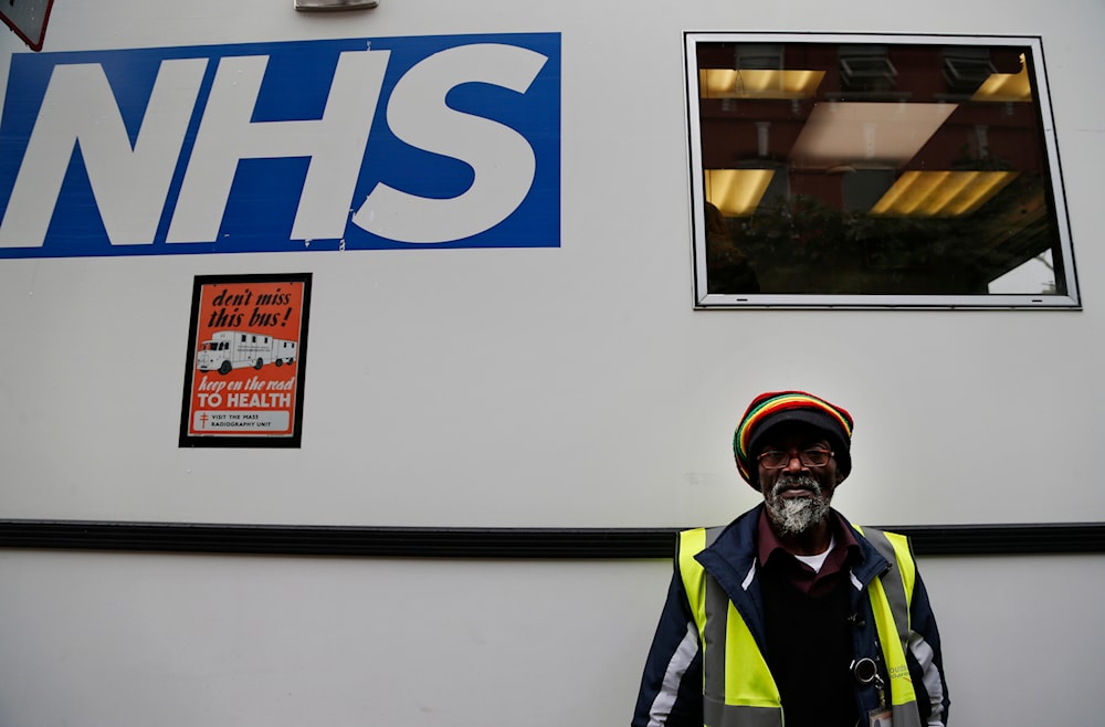 In this Wednesday, Oct. 16, 2013 photo, volunteer Horace Reid, 58, waits outside an X-ray van, parked outside a homeless shelter, in London. (AP)