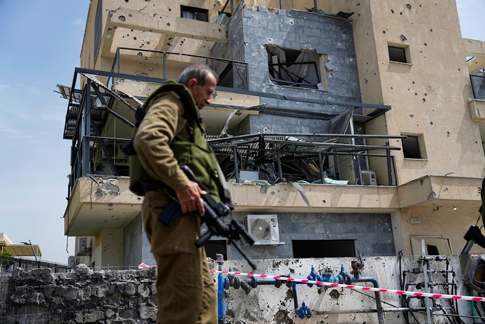 Israeli security forces examine the site hit by a rocket fired from Lebanon, in 