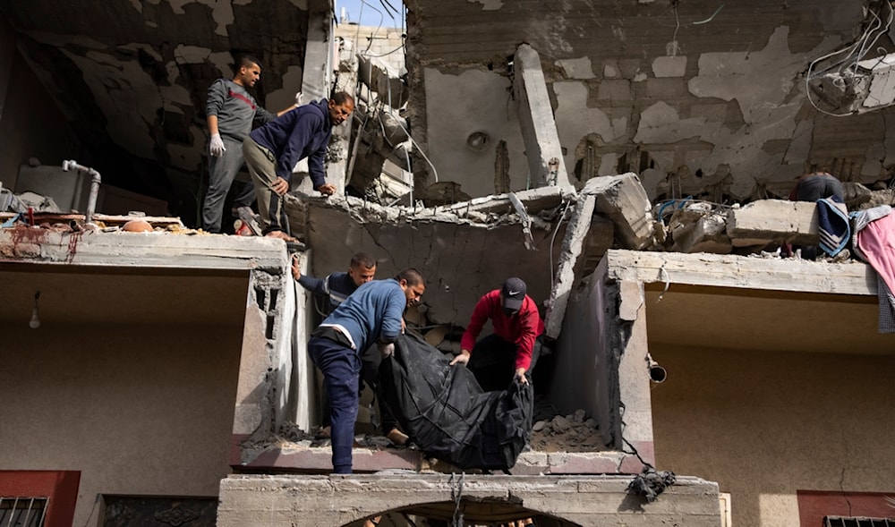 Palestinians carry the body of a woman found under the rubble of a destroyed building following an Israeli airstrike in Rafah, Gaza Strip, on Wednesday, March 27, 2024. (AP)