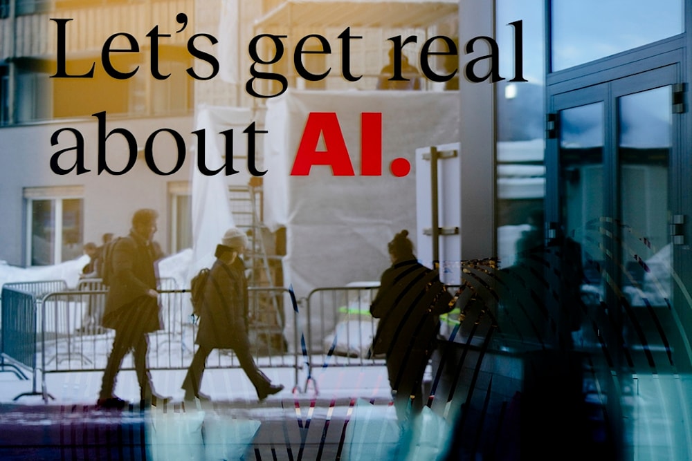 People reflected in a window of a hotel at the Davos Promenade with a slogan about AI alongside the World Economic Forum in Davos, Switzerland, Monday, Jan. 15, 2024 (AP)