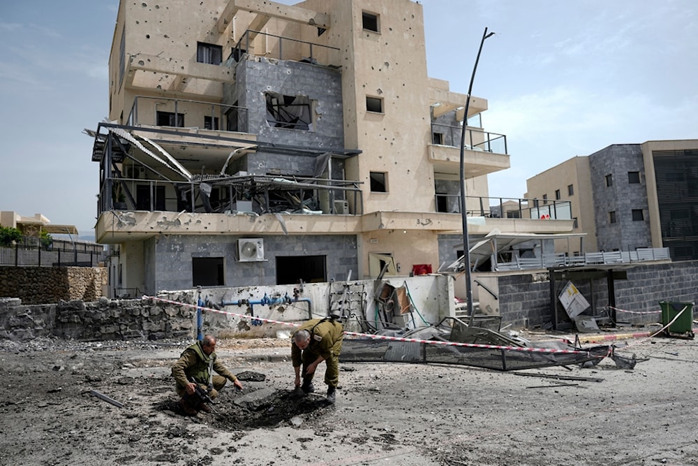 Israeli occupation forces examine the site hit by a rocket fired from Lebanon, in 'Kiryat Shmona', northern occupied Palestine, Wednesday, March 27, 2024. (AP)