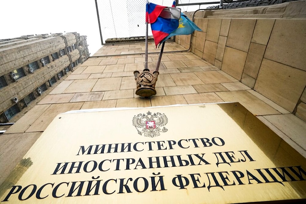 A Russian national flag flutters in the wind next to the sign of the Russian Foreign Ministry building in Moscow, Russia, Wednesday, Jan. 26, 2022. (AP)