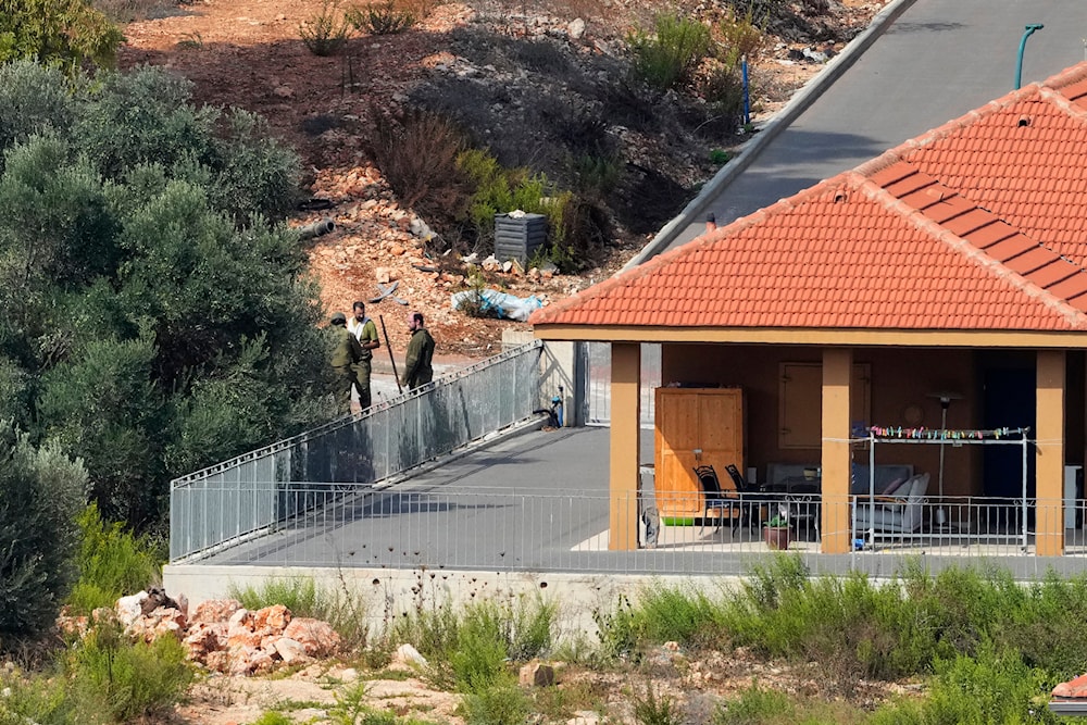 Israeli occupation forces deploy between houses in the 'Metula' settlement, as seen from Kfar Kila, Lebanon, Monday, Oct. 9, 2023. (AP)