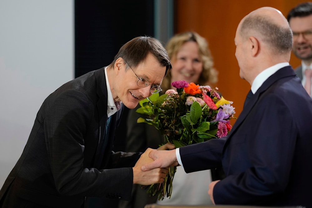 German Chancellor Olaf Scholz, right, congratulates Health Minister Karl Lauterbach on his birthday during the cabinet meeting of the German government at the chancellery in Berlin, Wednesday, Feb. 21, 2024. (AP)
