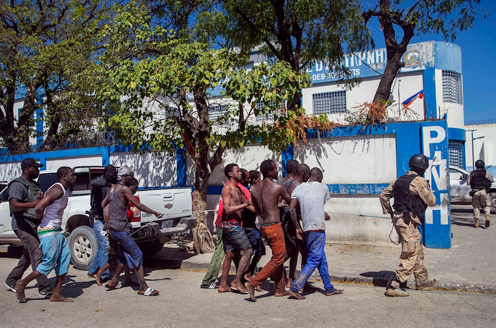 Recaptured inmates are escorted by police back to the Croix-des-Bouquets Civil Prison after an attempted breakout, in Port-au-Prince, Haiti, Thursday, Feb. 25, 2021.(AP)
