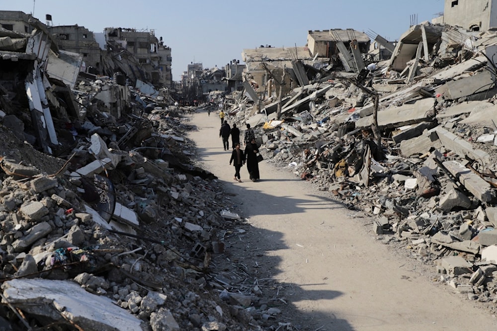 Palestinians walk through the destruction from the Israeli offensive in Jabaliya refugee camp in the Gaza Strip on Thursday, Feb. 29, 2024. (AP)