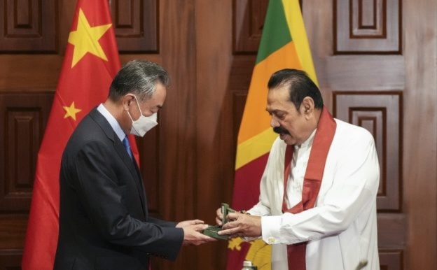 Sri Lankan Prime minister Mahinda Rajapaksa right presents a souvenir to Chinese foreign minister Wang before their meeting in Colombo, Sri Lanka, Sunday, January 9, 2022. (AP)