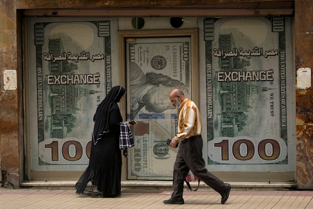 Egyptians walk past an exchange office in Cairo, Egypt, Wednesday, March 6, 2024. (AP)