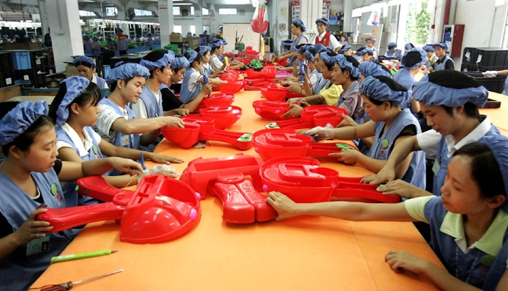 Workers assemble toy cars at the production line of Dongguan Da Lang Wealthwise Plastic Factory in Dongguan, China. (AP)