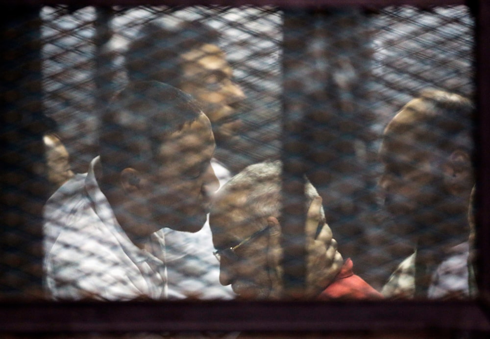 Muslim Brotherhood spiritual leader Mohammed Badie is greeted by other group members at the defendants cage in a makeshift courtroom at the Torah prison, southern Cairo, Egypt, July 21, 2015 (AP)