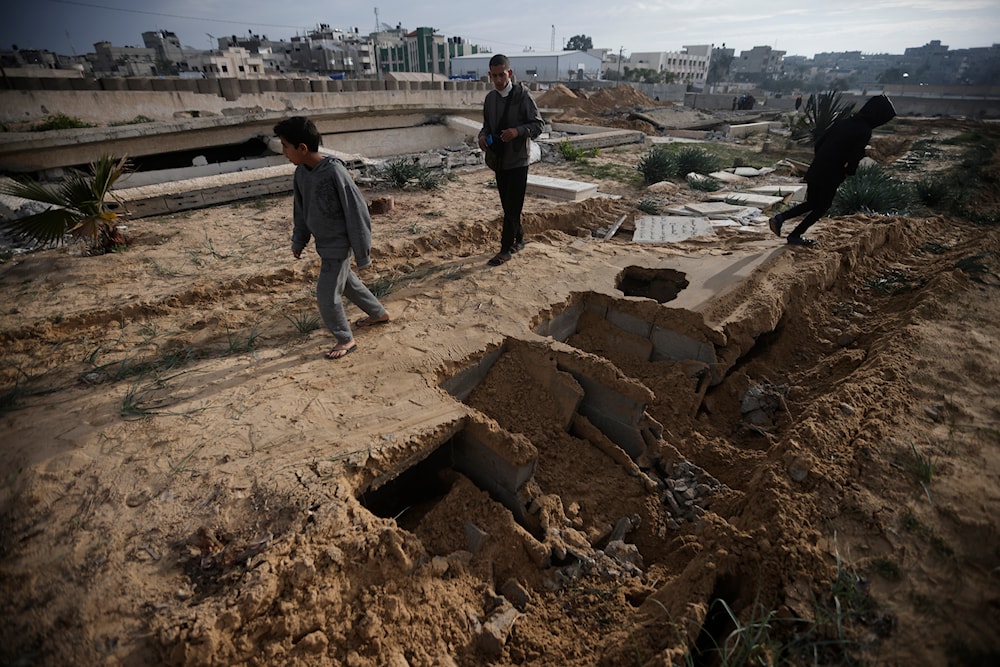 Palestinians inspect graves destroyed by an Israeli tank raid over a cemetery in Khan Younis refugee camp, southern Gaza Strip, Wednesday, Jan. 17, 2024. (AP)
