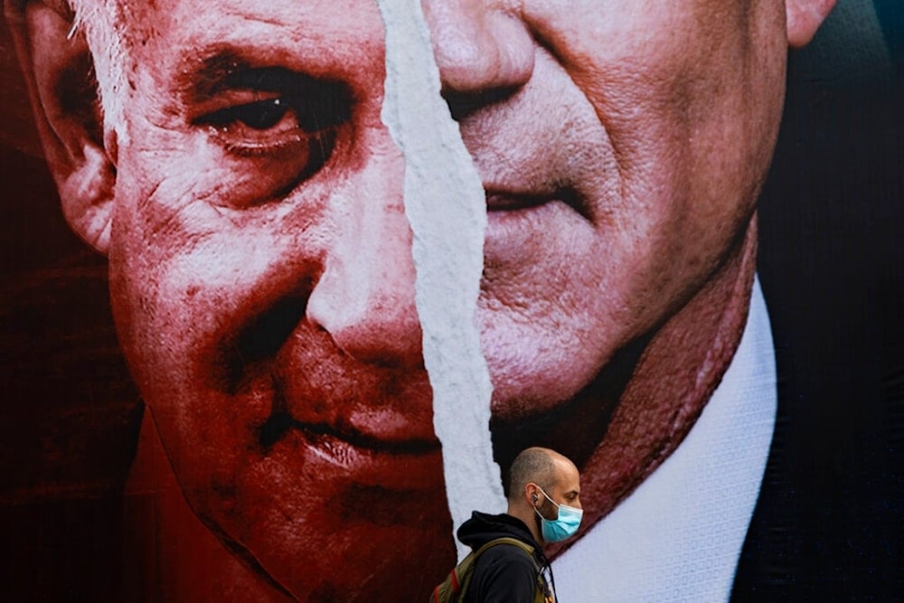 In this March. 11, 2021 file photo, an election campaign billboard for the Blue and White party, the opposition party led by Benny Gantz, right, and Prime Minister Benjamin Netanyahu, left, hangs on a street in 