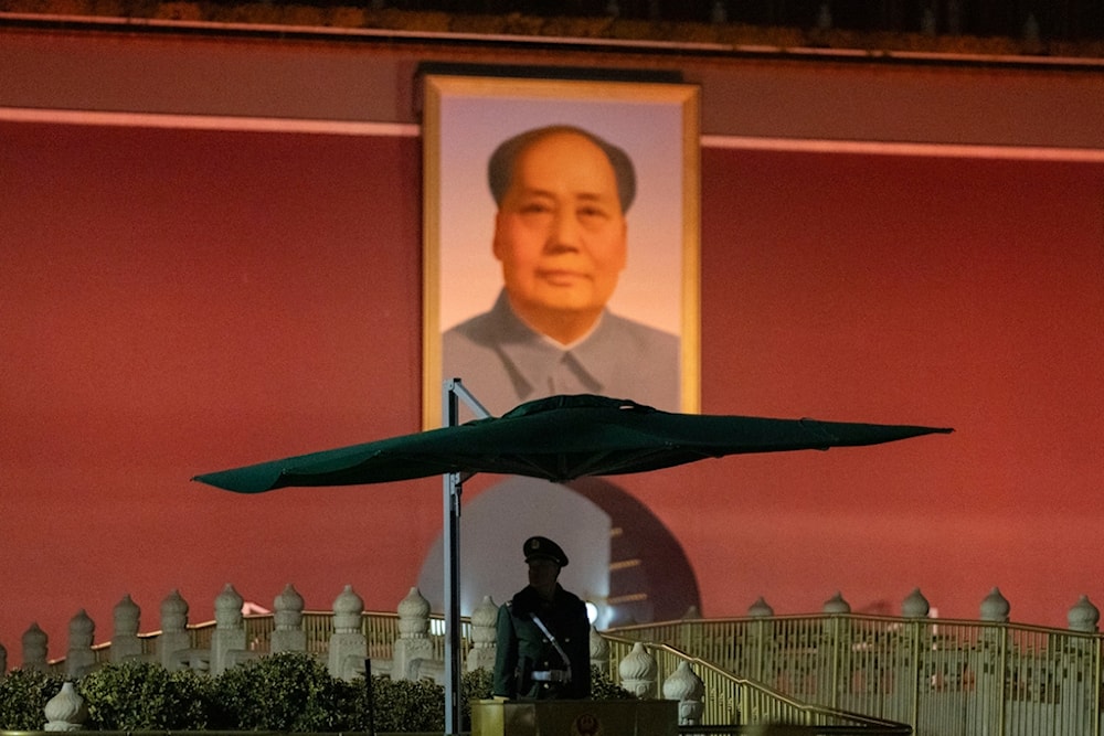 A Chinese paramilitary policeman stands guard near the portrait of Mao Zedong on Tiananmen Gate before the opening session of the National People's Congress (NPC) in Beijing, China, Tuesday, March 5, 2024. (AP)
