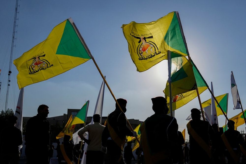 People holding the Kataib Hezbollah flag, Baghdad, Iraq, Thursday, Feb. 8, 2024 (AP Photo/Hadi Mizban)