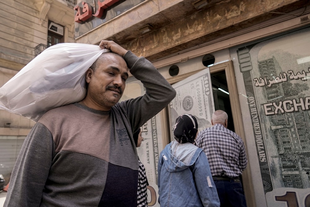 An Egyptian man walks past an exchange office in Cairo, Egypt, Wednesday, March 6, 2024. (AP)