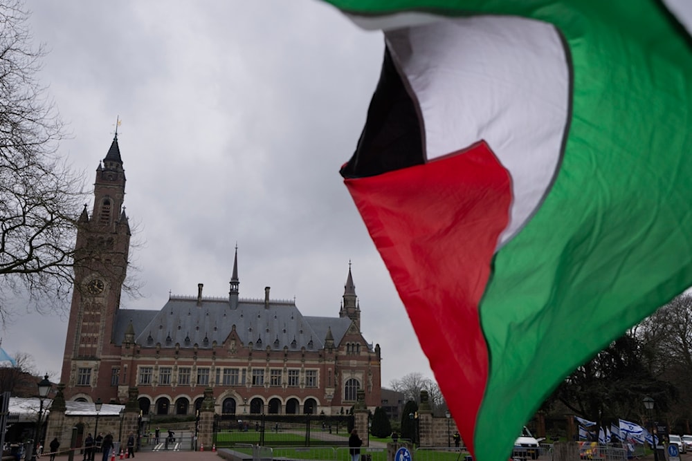 A Palestinian flag flies outside the United Nations' highest court, rear, during historic hearings in The Hague, Netherlands, Wednesday, Feb. 21, 2024. (AP)